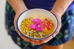 Crop woman with bowl of healthy breakfast