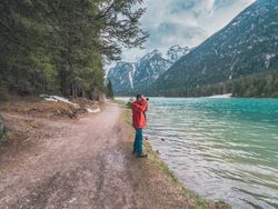 Male photographer near mountains and lake
