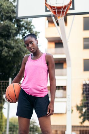 Confident Basketball Player Holding Ball with Determination