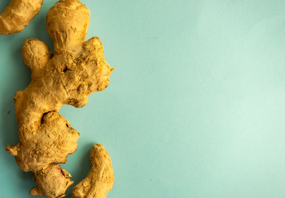 Top view of ginger root on green background for detox drink