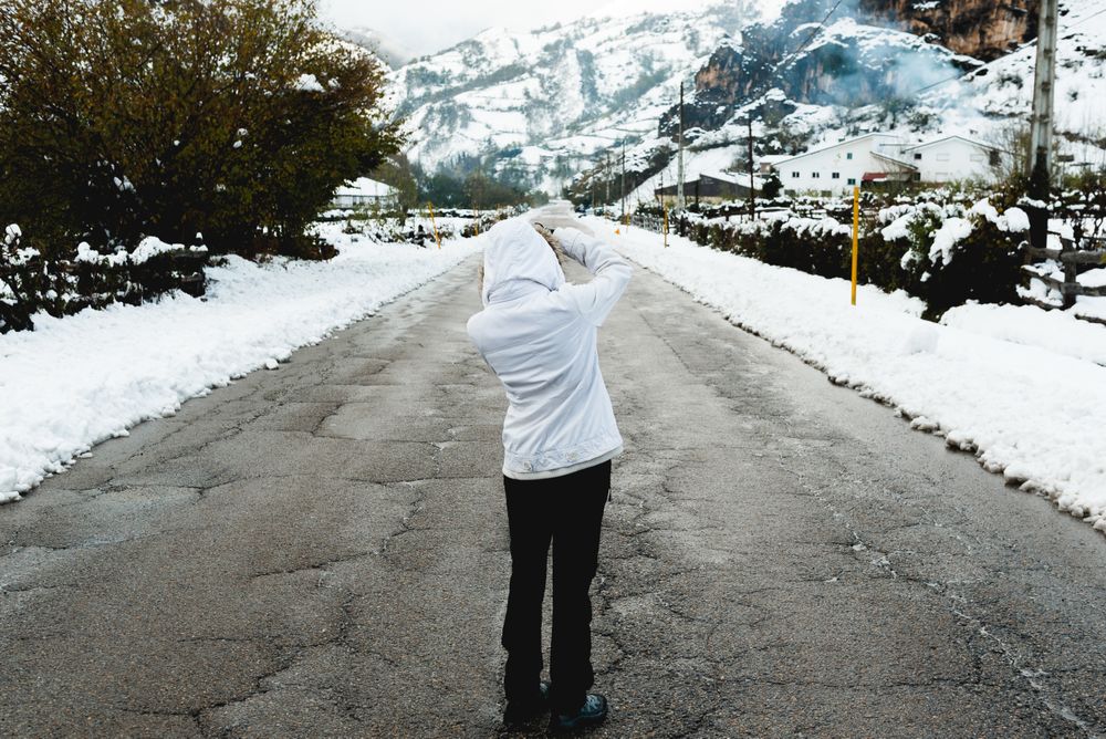 Anonymous person standing on road in countryside