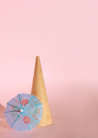 Cone of ice cream with blue cocktail parasol