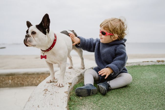 Funny kid with dog on beach