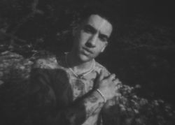 B&W shot of tattooed male in the shadows