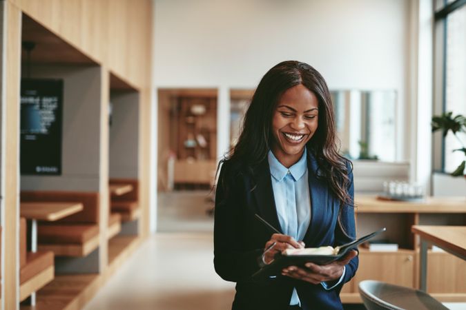 Smiling business woman taking notes in a bright modern office