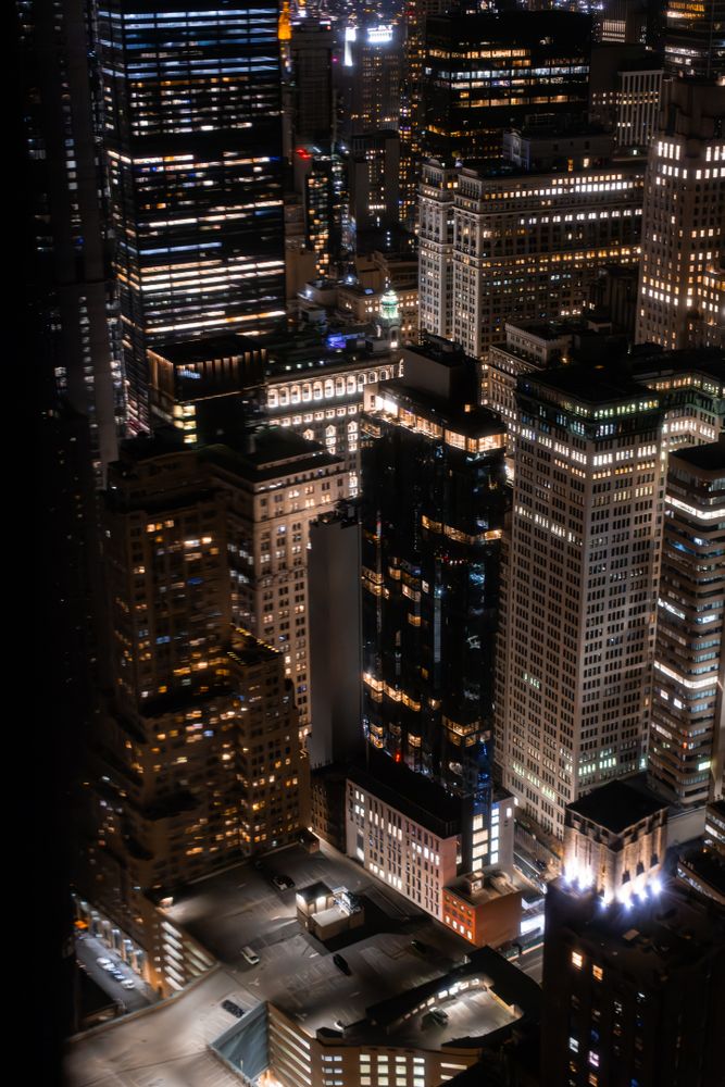 Aerial Night View of New York City Streets in Manhattan with Residential Building Rooftop Parking for Cars. Helicopter View of a Big City During Night Time
