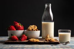 Glasses near fruits and cookies on table near napkin