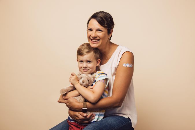 Woman and boy with bandage on arm after getting a vaccine