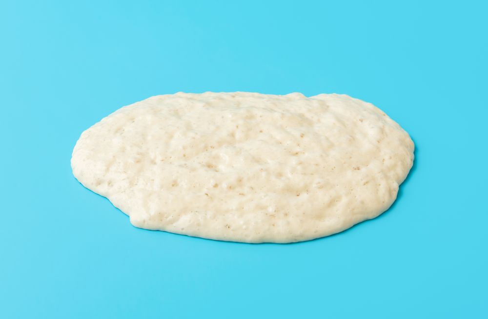 Sourdough starter spread on a blue table