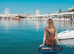 faceless woman looking on water and city