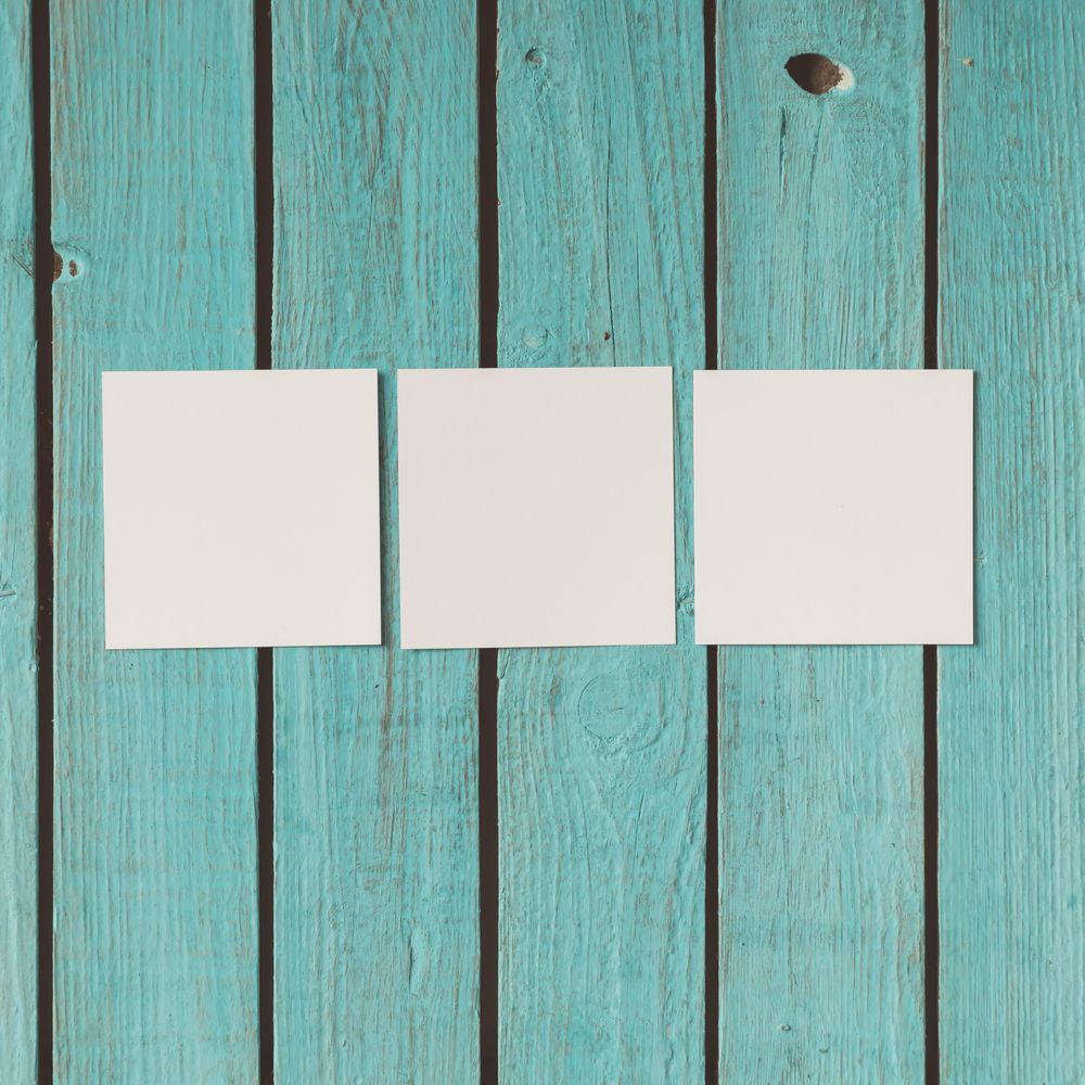 Three blank photos on blue wooden background