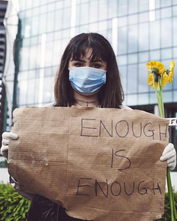 London, England, United Kingdom - June 6th, 2020: Woman in facemask with simple sign and flowers