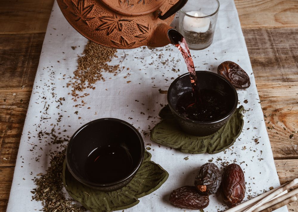 Aromatic tea dates and clay teapot on table