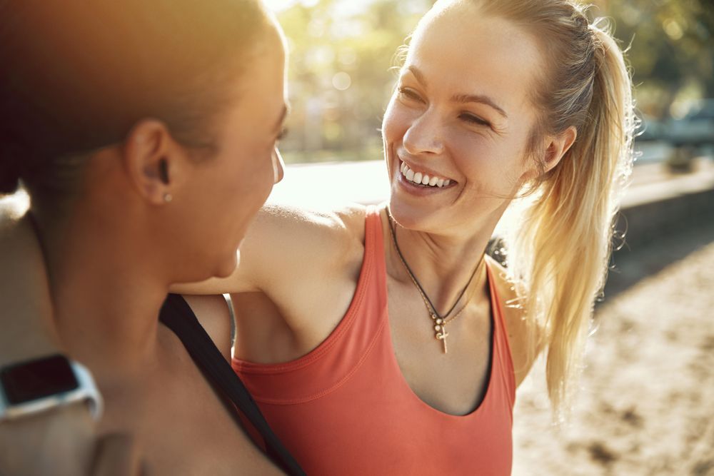 Close up of two smiling woman outside