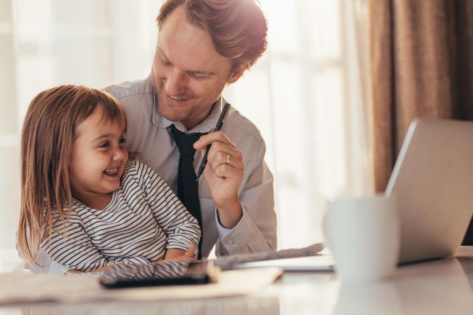 Dad working from home having fun with daughter