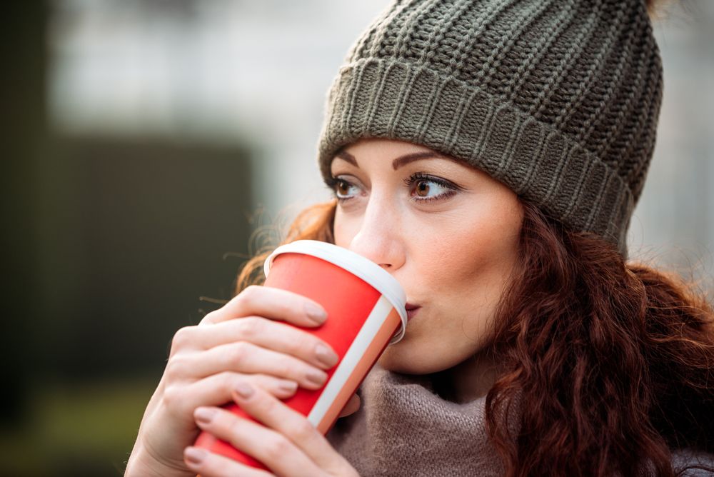 Beautiful woman drinking coffee in the streets of Madrid on winter