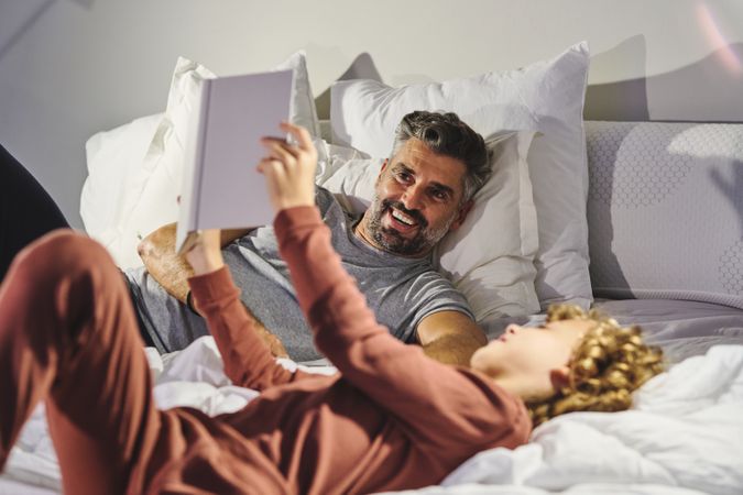 Laughing father and son reading bedtime story together