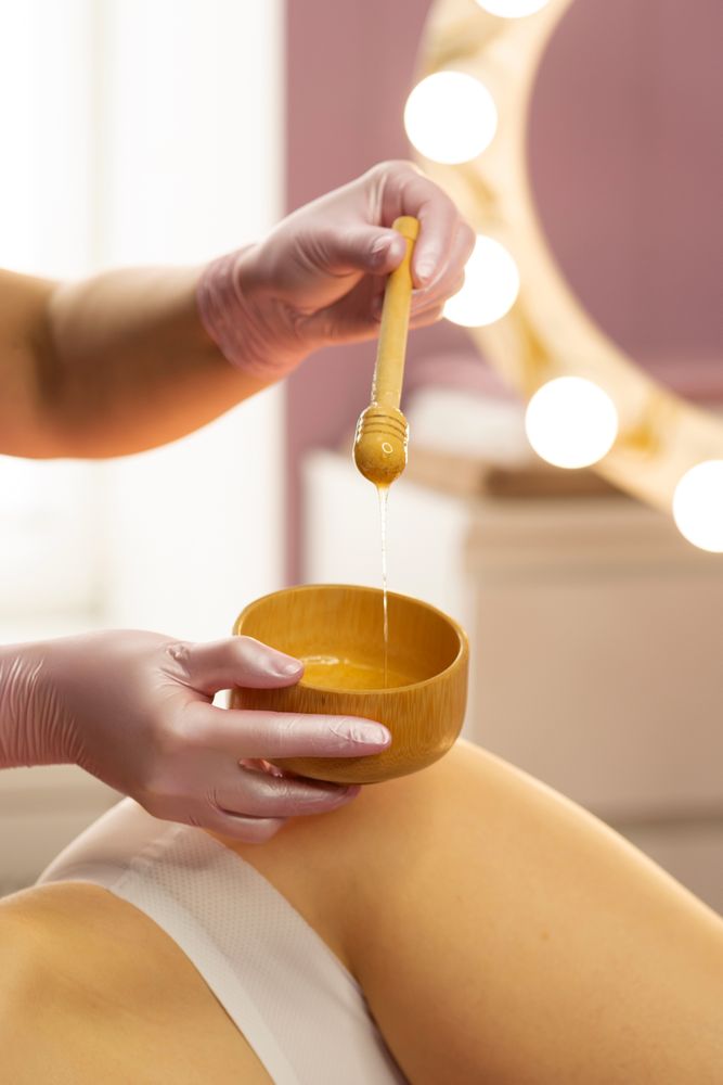 Therapist preparing honey mixture during beauty body treatment.