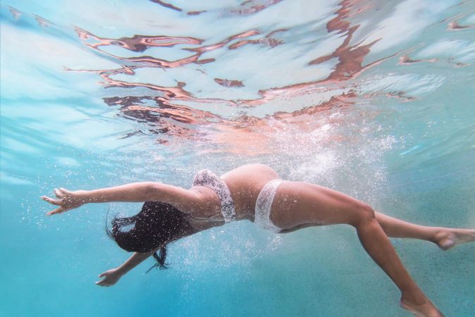 Underwater shot of pregnant woman swimming