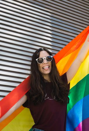 Woman posing happily with the LGBT flag
