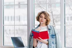 Thoughtful Girl Freelancer Near Window With Notebook.