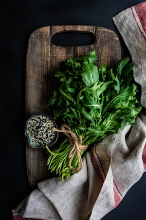 Arugula and sesame seeds on bread board