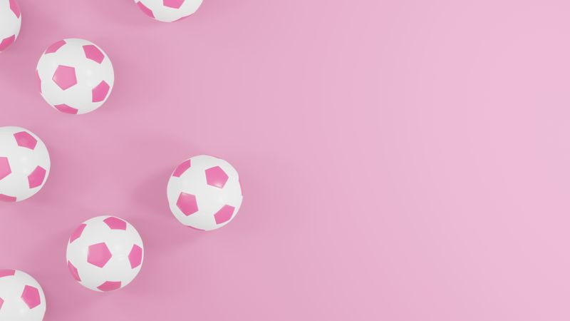 Pink soccer balls on pink background with copy space