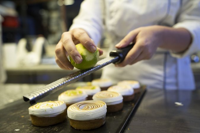 Cook grating lime on meringue cookies