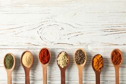 Row of wooden spoons full of spice with copy space