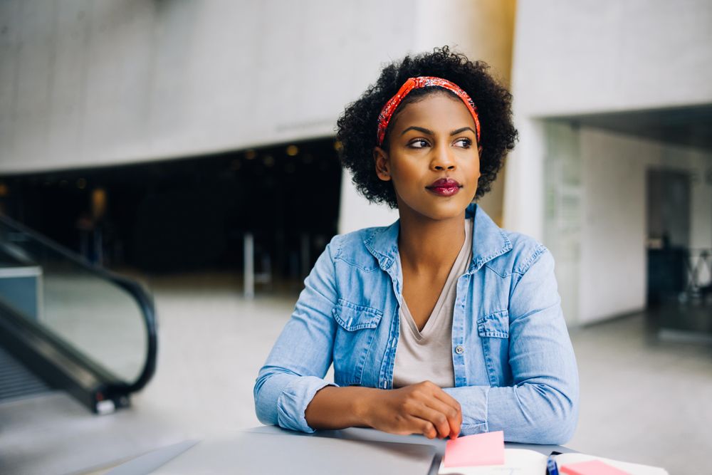 Woman sitting at table at work in an open office