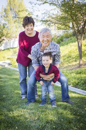 Chinese Grandparents Having Fun with Their Grandson Outside