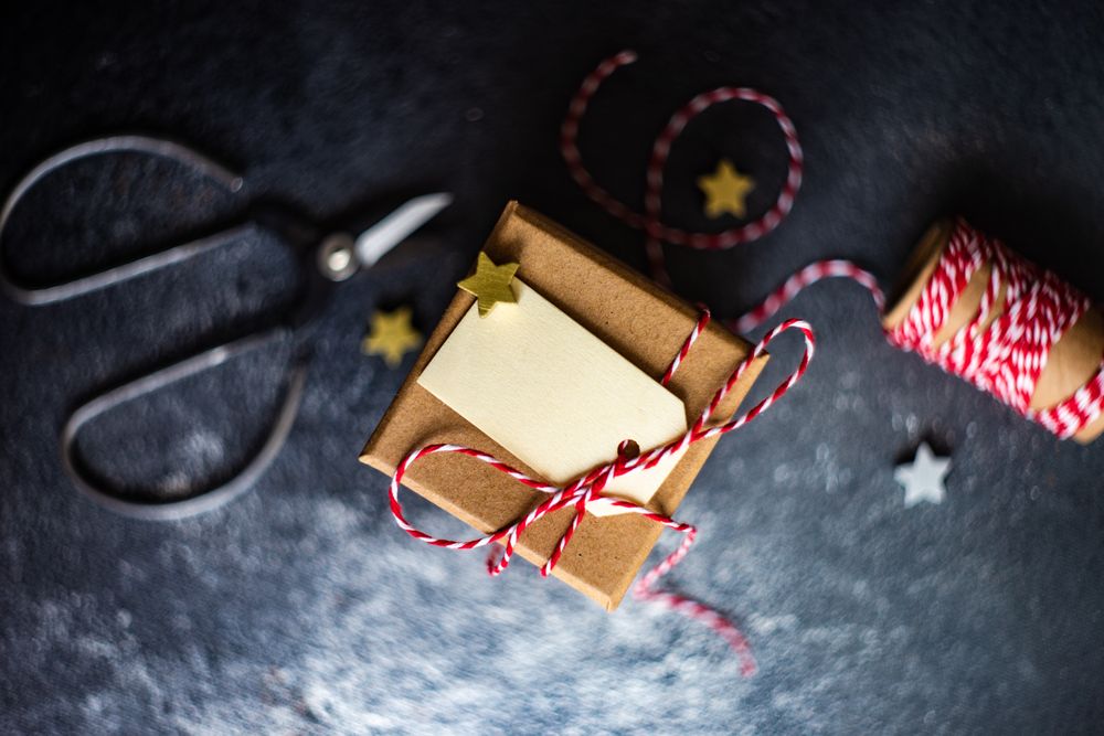 Top view of brown Christmas gifts with red string and scissors