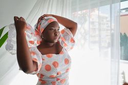 Black woman putting kerchief on head