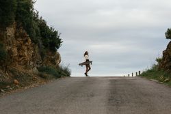 Pensive woman standing with longboard