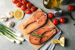 Composition with salmon meat and ingredients on gray background, top view
