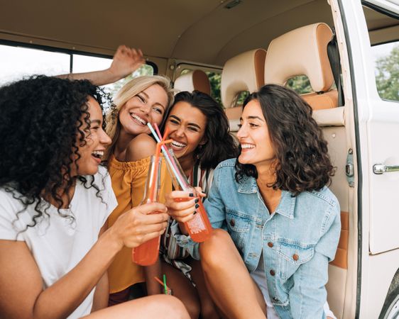 Happy women sitting together in van during road trip