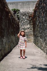 Girl in narrow stone walkway looking up