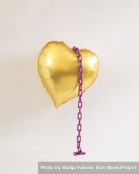 Golden heart balloon in the air with violet purple chains 5nqM20