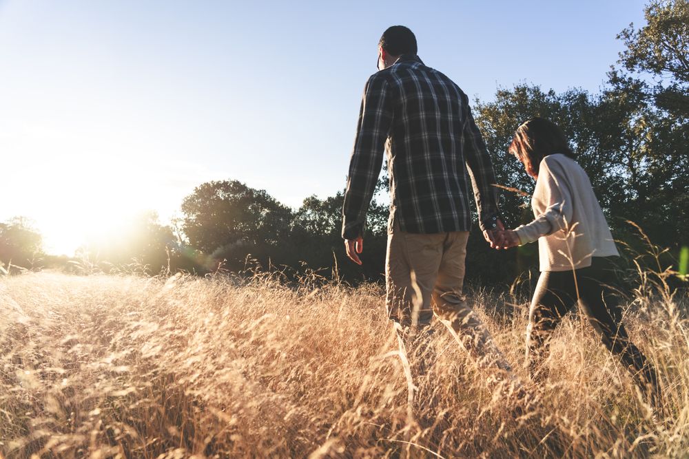 Loving couple walking in golden rural field