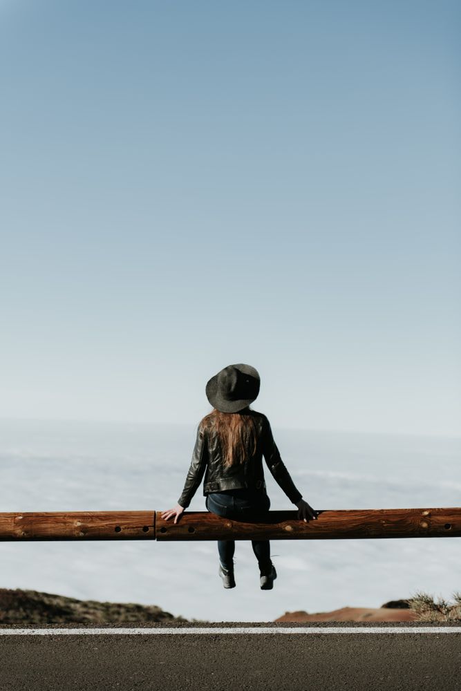 Woman on fence on hill