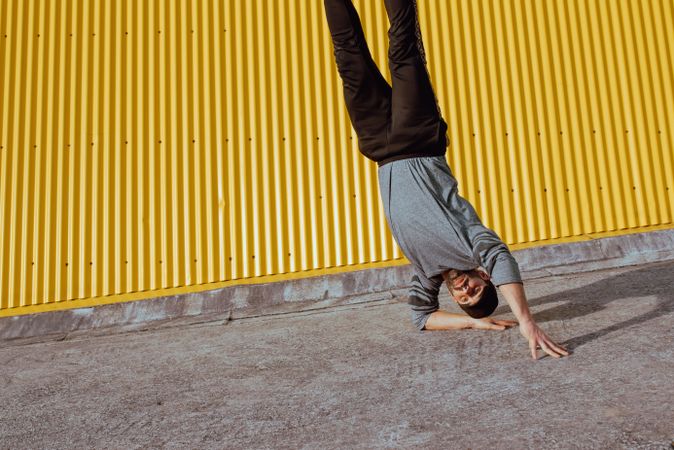 Man performing handstand near wall