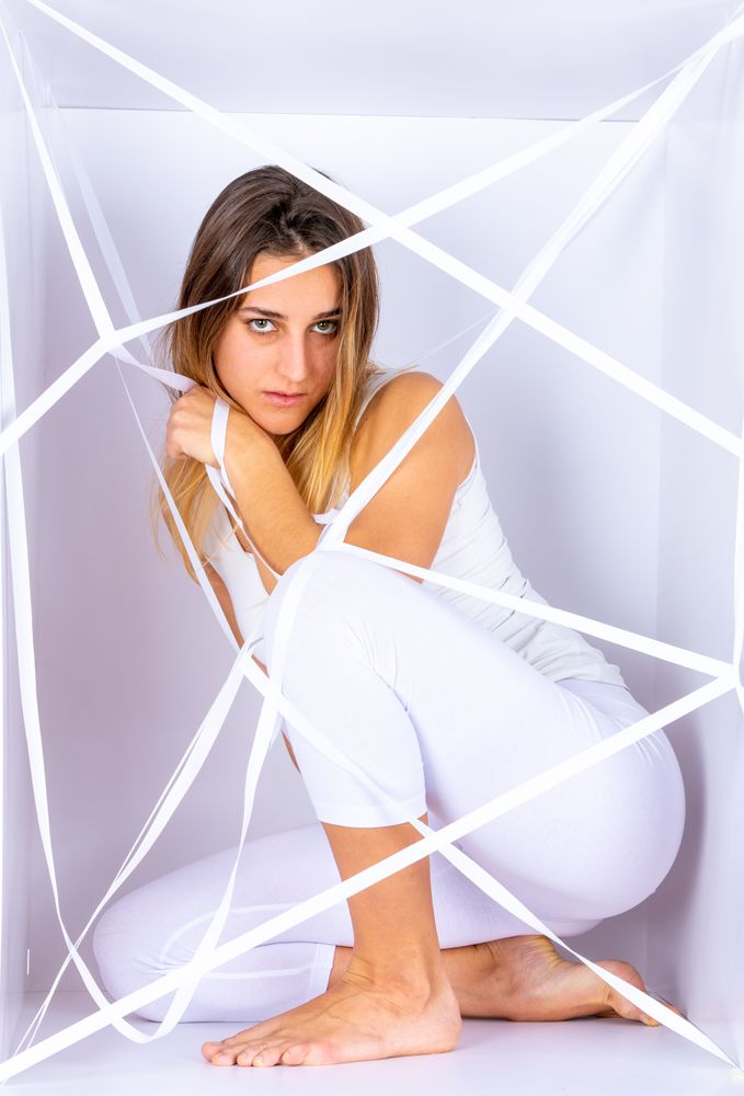 Woman in white box with straps