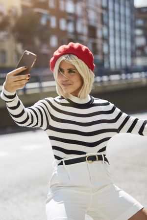 female in red beret taking selfie
