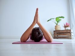 Unrecognizable woman practicing yoga at home