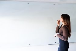 Transgender woman standing at dry erase board