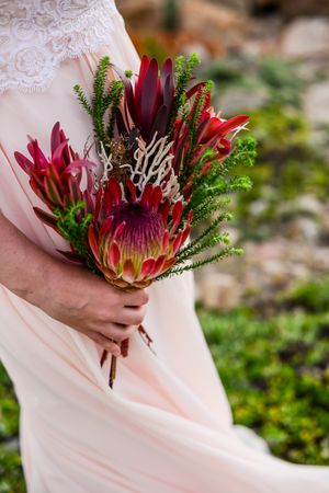 Woman holding red and green bouquet