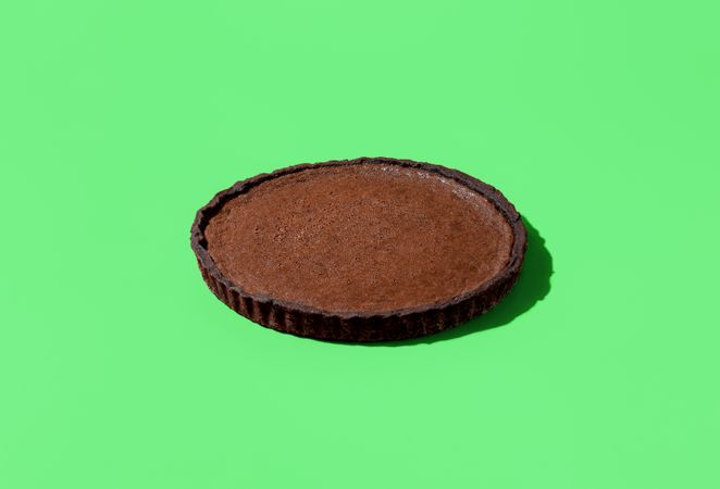Chocolate tart in bright light isolated on a green background
