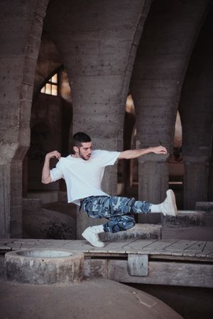 Skillful b boy showing technique in aged cathedral