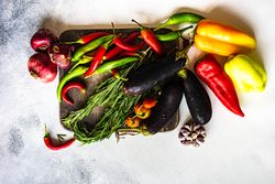 Top view of fresh vegetables and herbs on wooden board with copy space