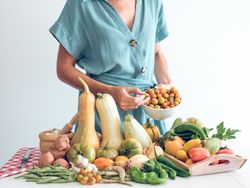 Crop woman with fresh ripe vegetables